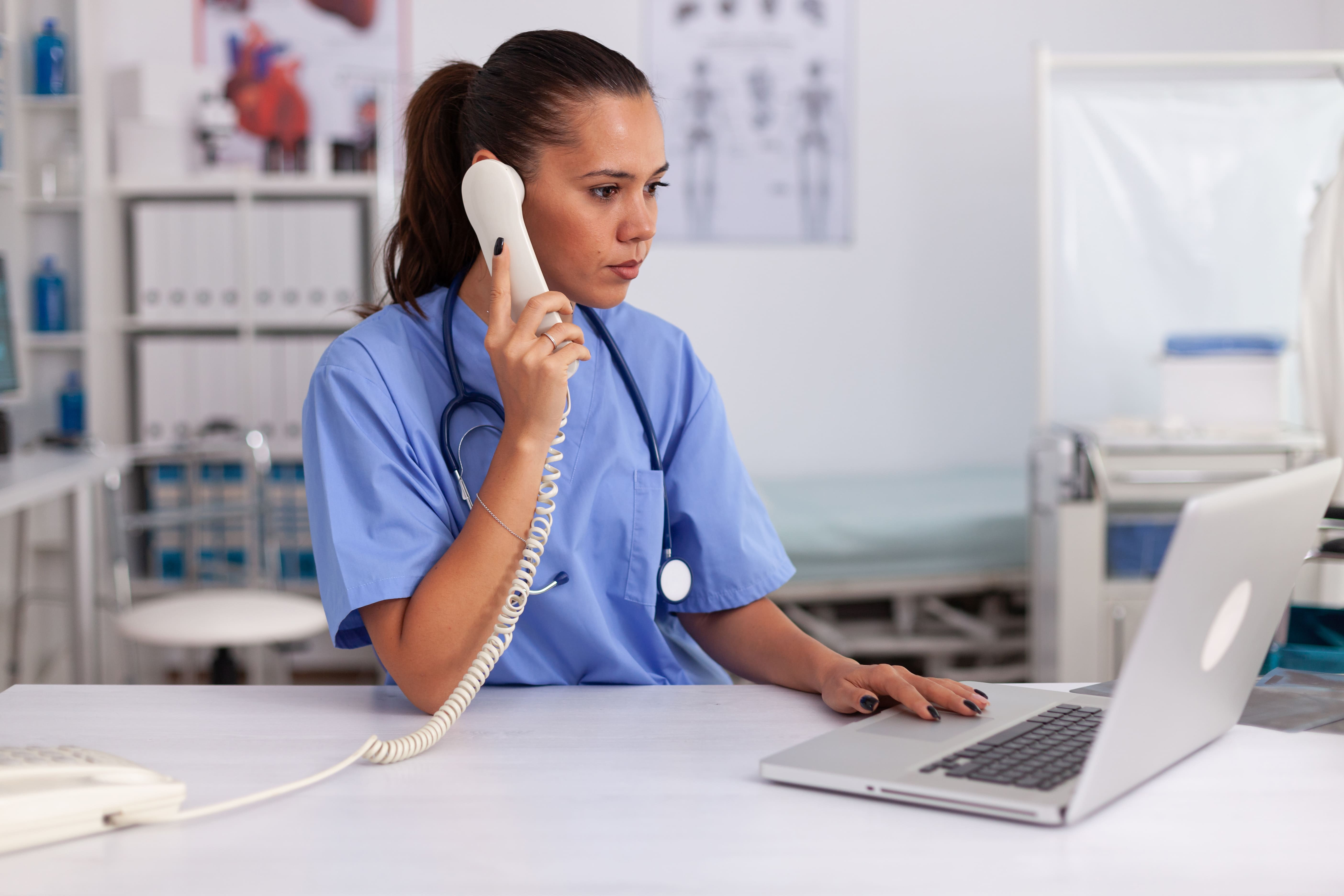 CareRCM free consultation form - Nurse on phone and laptop for medical billing services