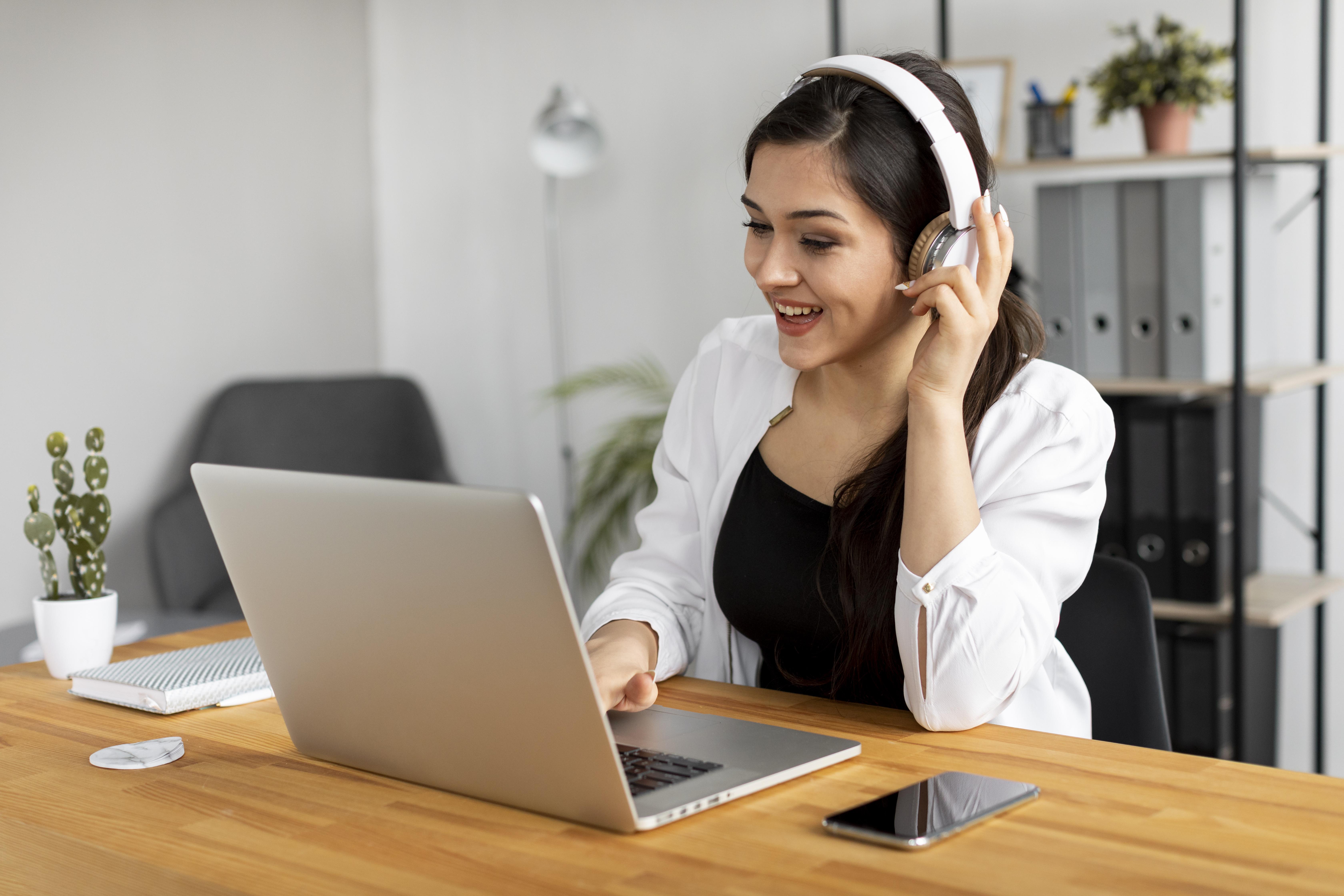 CareRCM free consultation - Woman with headset working on laptop for medical billing services